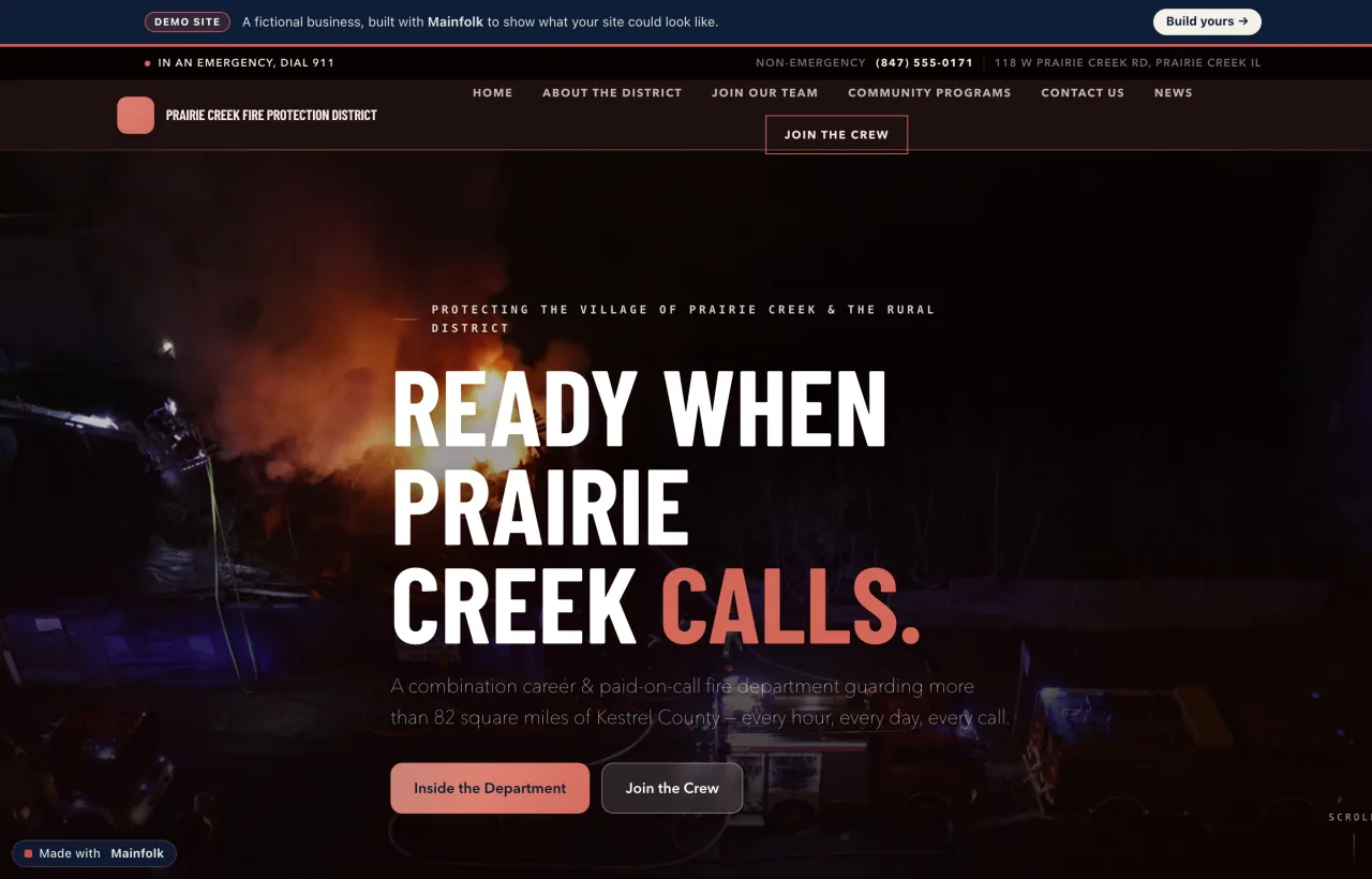 The Prairie Creek Fire Protection District website built on Mainfolk: a red emergency alert strip across the top, a night photo of a fire engine leaving the station, and a large 'Ready when Prairie Creek calls' recruitment headline.