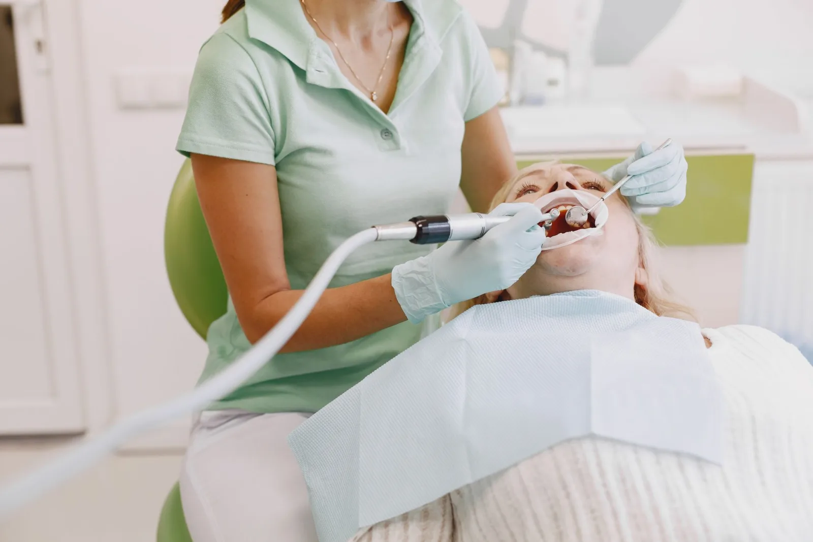 Dentist performing an oral examination on a patient in a clinic setting.