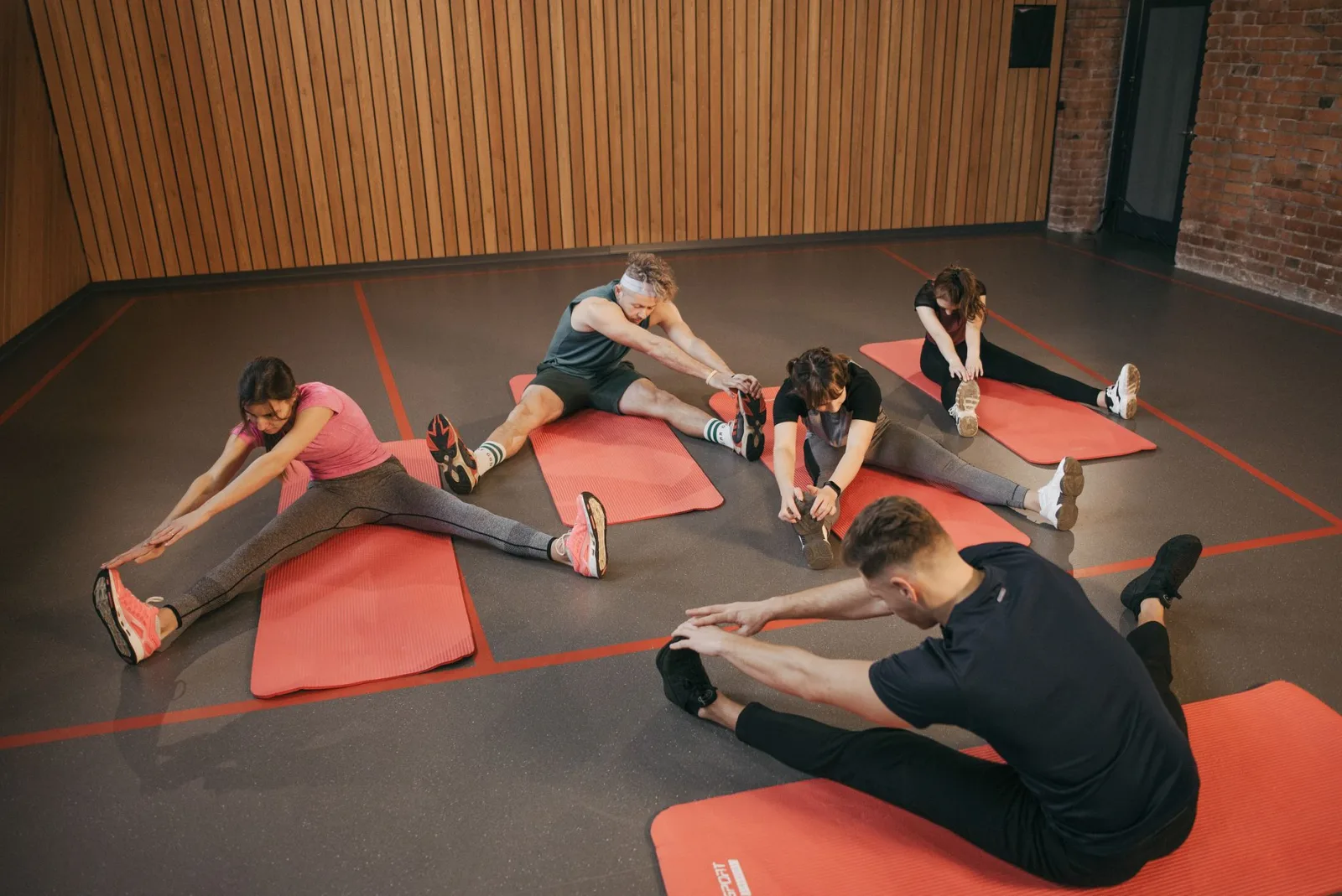 Adults in a yoga studio stretch on mats, promoting fitness and flexibility.