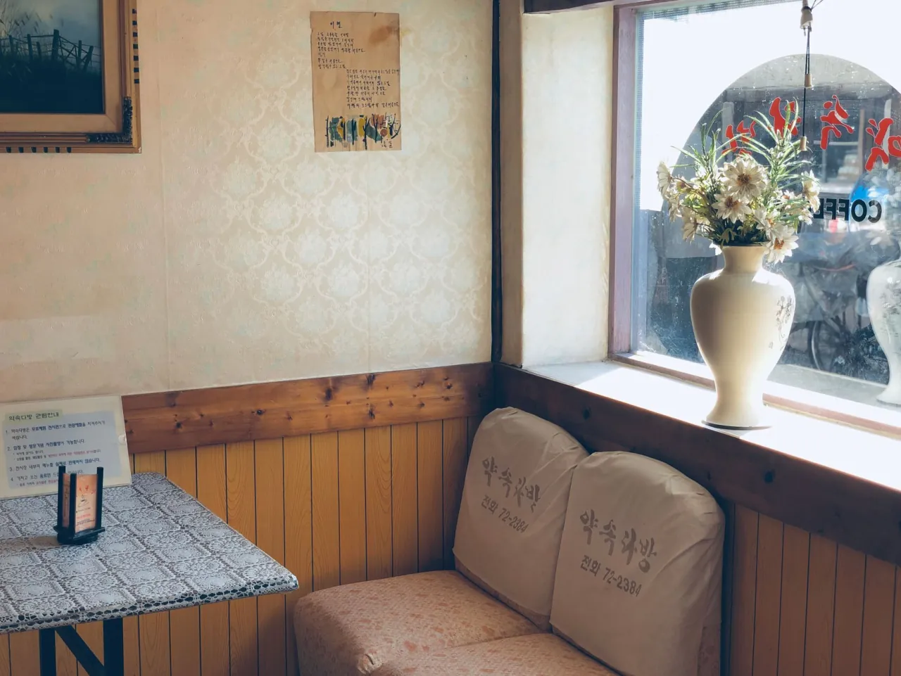 A sunlit corner of the café with a couch and flowers