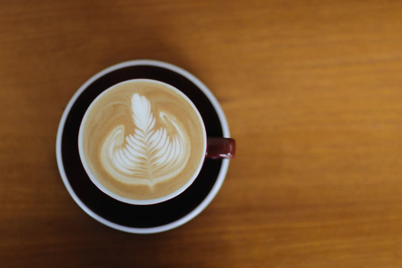 A cappuccino with latte art on a wooden table